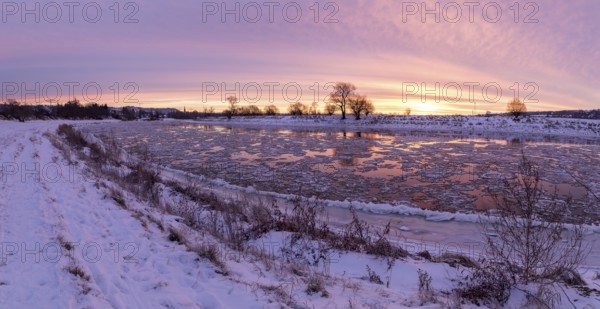 Panorama on a cold winter morning on the Elbe with floating ice floes, snow and dawn at sunrise, Kötzschenbroda, Radebeul, Saxony, Germany