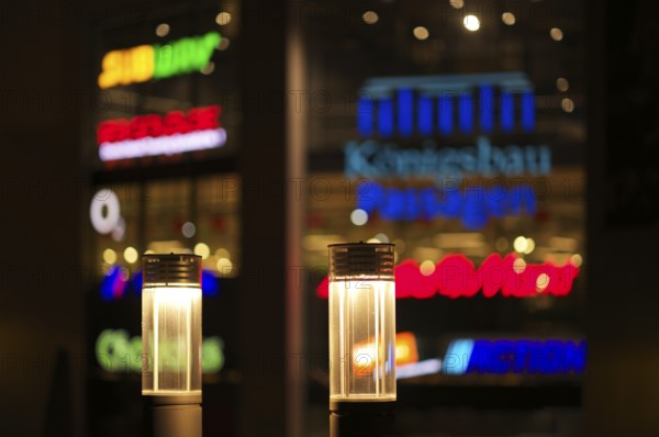 Night view, street lamps, neon lighting behind in blur, logo Mediamarkt, Tegut, Action, Subway, Postbank, ChaHaus, 123Gold.de, Königsbau Passagen, shopping center, Stuttgart, Baden-Württemberg, Germany