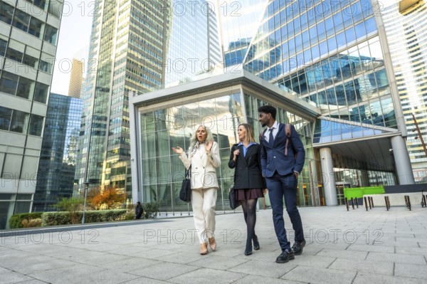 Diverse business professionals walking and discussing outdoors in a contemporary financial district, reflecting collaboration, urban corporate life, and international business networking