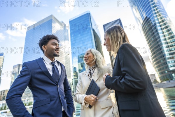 Diverse business professionals networking and discussing projects outdoors in front of modern corporate buildings, symbolizing teamwork, global partnership, and career growth in an urban setting