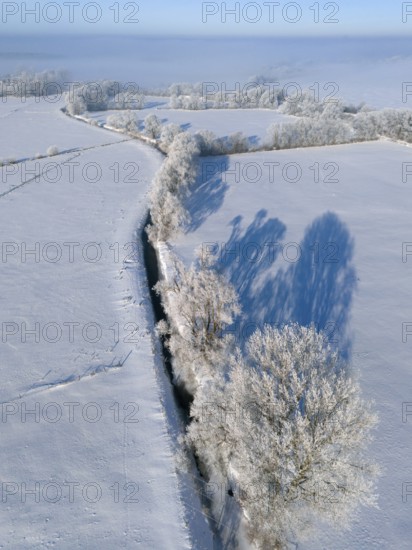 Snowy fields with a straight river surrounded by frosty trees under a blue sky, Fuhse river, Bülten, Ilsede, Peine district, Lower Saxony, Germany