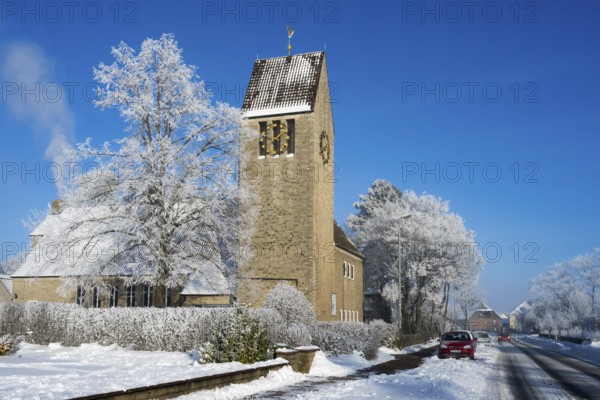 Village church with snow-covered trees against clear blue sky, car on the road, St. Mark's Church, snow, hoarfrost, Bülten, Ilsede, Lower Saxony, Germany