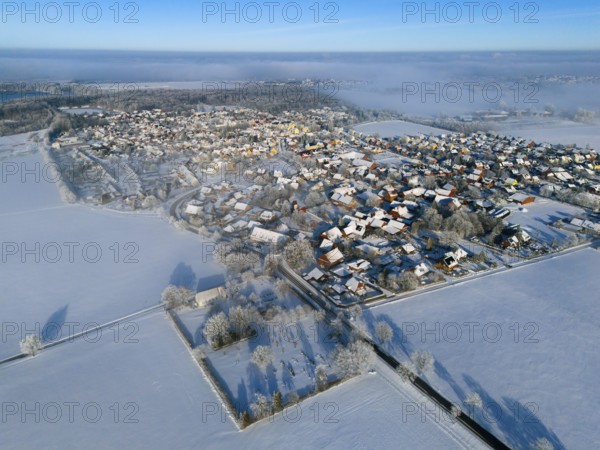 Winter aerial view of a village with snowy fields and clear blue sky, aerial view, partly fog, Bülten, Ilsede, Lower Saxony, Germany