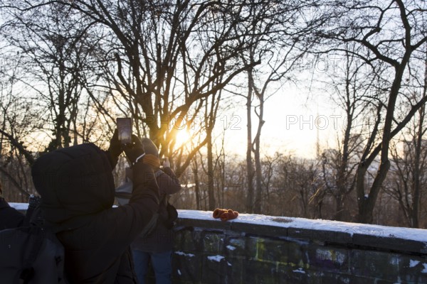 People take pictures of the Berlin TV Tower with their cell phones from Volkspark Friedrichshain on 07.01.2026