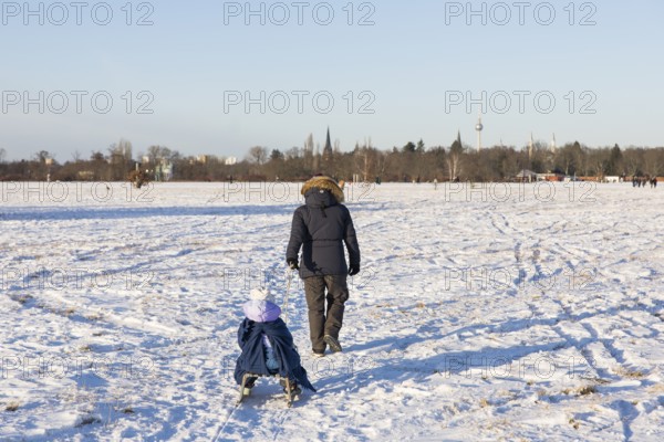 A woman pulls a child on a sled on Tempelhofer Feld in Berlin on 11.01.2026