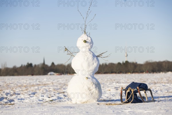 A snowman stands next to a sled on Tempelhofer Feld in Berlin on 11.01.2026
