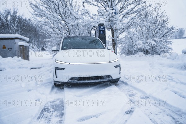 Electric car charging at a charging station in a snowy winter landscape, Tesla Model Y electric car, ENBW charging station, Waldachtal, Freudenstadt district, Germany