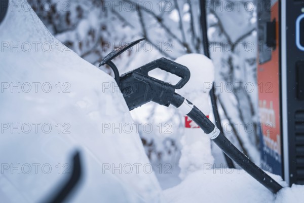 Close-up of a charging cable connected to an electric car in snowy surroundings, Tesla Model Y electric car, ENBW charging station, Waldachtal, Freudenstadt district, Germany