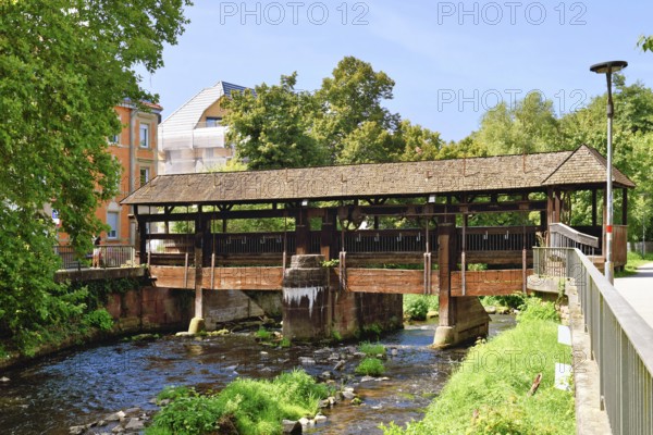 Ettlingen, Germany - August 13th 2025: Old wooden bridge over the Alb river. Historic landmark on a sunny day