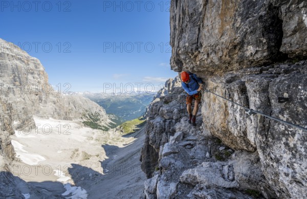 Mountaineers on a narrow band of rocks on the Via Ferrata Bocciere Centrale via ferrata, spectacular mountain landscape with steep rock faces, Brenta-Adamello Nature Park, Trentino, Italy