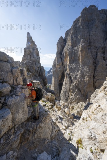 Climbers on the Via Ferrata Bocciere Centrale via ferrata, spectacular mountain landscape with steep cliffs and rock towers, Brenta Mountains, Parco Naturale Brenta-Adamello, Trentino, Italy