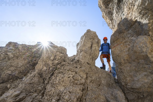 Mountaineers between rocks on the Via Ferrata Bocciere Centrale Via Ferrata, Sun Star, Brenta Mountains, Brenta-Adamello Natural Park, Trentino, Italy