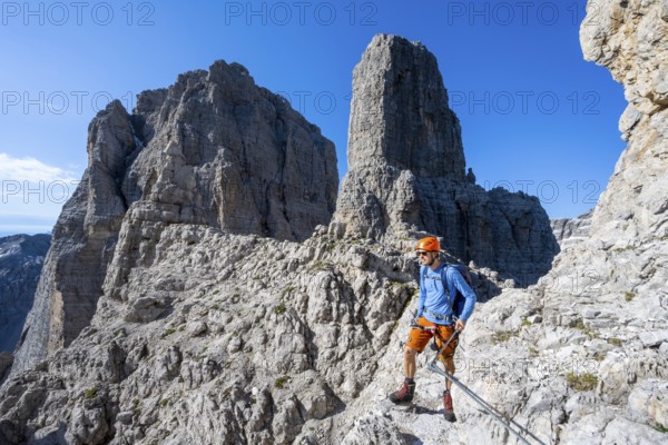 Climbers on the Via Ferrata Bocciere Centrale via ferrata, spectacular mountain landscape with steep cliffs and rock towers, Brenta Mountains, Parco Naturale Brenta-Adamello, Trentino, Italy