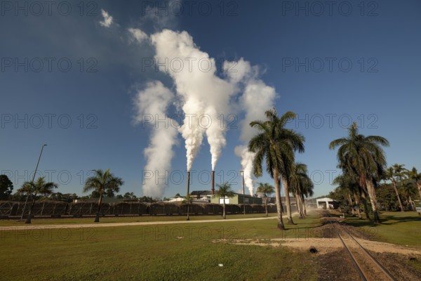 August 19, 2020, Sugar Mill. Industrial chimneys smoking under a clear blue sky on a bright sunny day. Tully, Queensland, Australia