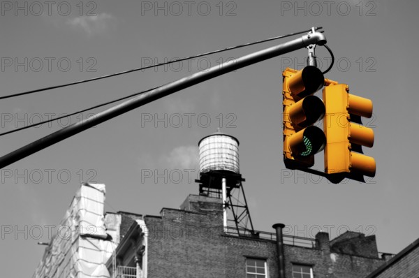 Yellow traffic light rear wooden water tank Downtown, New York City, USA