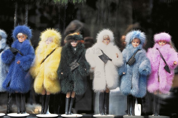 Barbie dolls in different colored fur coats in a shop window, New York City, USA