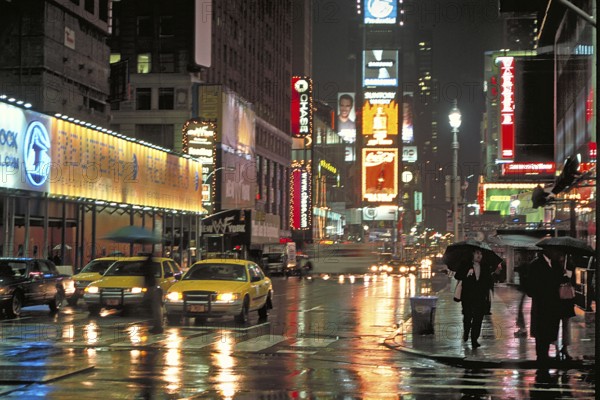 Illuminated advertising on Time Square at night when it rains, New York City, USA