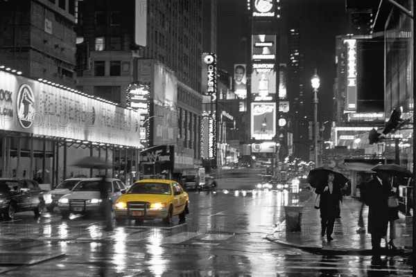 Illuminated advertising on Time Square at night when it rains, black and white, New York City, USA