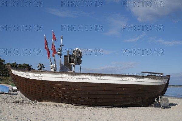 Boat with fishing flags lying on sandy beach, blue sky, Binz, seaside resort, Rügen island, Baltic Sea, Mecklenburg-Western Pomerania, Germany
