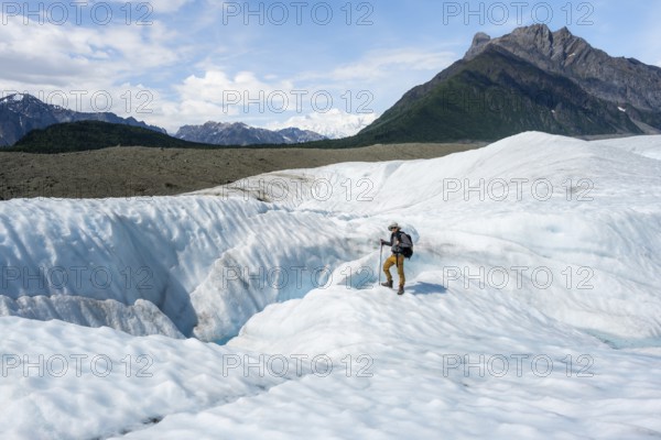 Mountaineers next to crevasses on Root Glacier ice, Wrangell St. Elias National Park, Alaska, USA