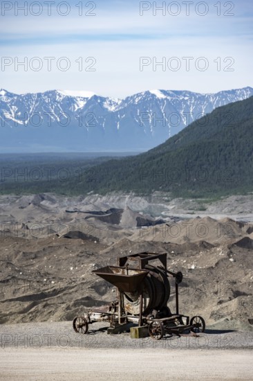 Old rusted moving mill for rock in front of mountain landscape with Kennicott Glacier, Historic Kennecott Copper Mine, National Historic Landmark, Wrangell St. Elias National Park, Alaska, USA