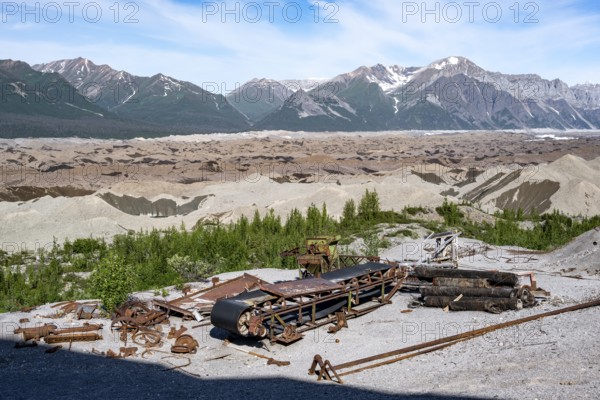 Old rusted metal scrap with conveyor belt, mountainous landscape and Kennicott Glacier, Historic Kennecott Copper Mine, National Historic Landmark, Kennicott, Wrangell St. Elias National Park, Alaska, USA