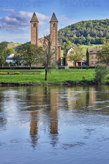 Moselle river, St. Salvator church, double tower, general architecture, houses, riverbank, hilly landscape, hills, forest, trees, meadow, abstract reflections on the water surface, blue sky, cumulus clouds, dramatic image processing, country road L98, Valwig, Cochem-Zell district, Rhineland-Palatinate, Germany