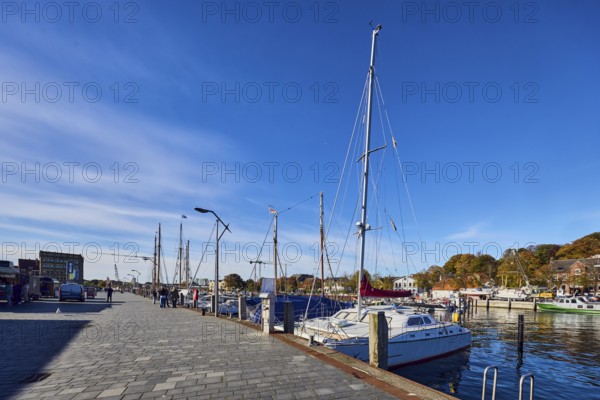Harbour, harbour basin, wharf, ships, sailboat, duckdalves, general architecture, houses, lantern, trees, pedestrians as accessories, blue sky, cirrus clouds, Hafenstraße road, Eckernförde district, Rendsburg-Eckernförde, Schleswig-Holstein, Germany