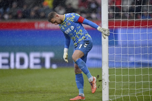 Goalkeeper Marvin Schwäbe 1. FC Koeln KOE (01) knocks clay off the post, snow, snow drift, winter, Voith-Arena, Heidenheim, Baden-Württemberg, Germany
