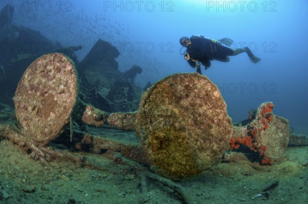 Underwater photo of diver swimming over Boonsung wreck looking at parts of former sunken tin excavator off coast of seaside resort Khao Lak, Andaman Sea, Indian Ocean, Thailand