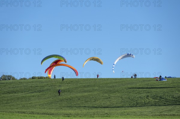 Paragliders practice on a meadow slope, Tauchersreuth, Middle Franconia, Bavaria, Germany