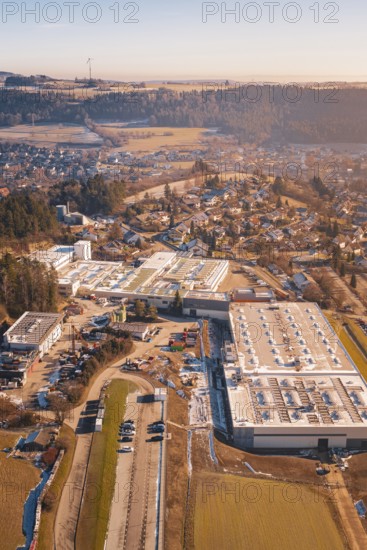Industrial plants next to a village in a hilly winter landscape, Glatten, Freudenstadt district, Germany