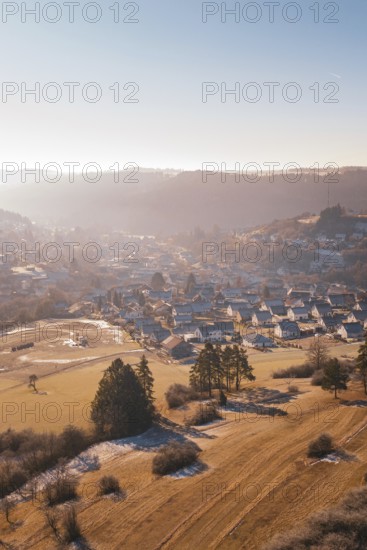 Wintery village in hilly landscape with morning sun, Glatten, Freudenstadt district, Germany