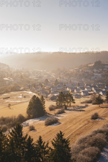 Village scenery in soft winter light with hills and trees, Glatten, Freudenstadt district, Germany
