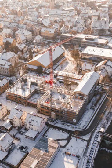 Close view of a snowy construction site in the middle of an urban residential area, Zellerschule building, Nagold, Black Forest, Germany
