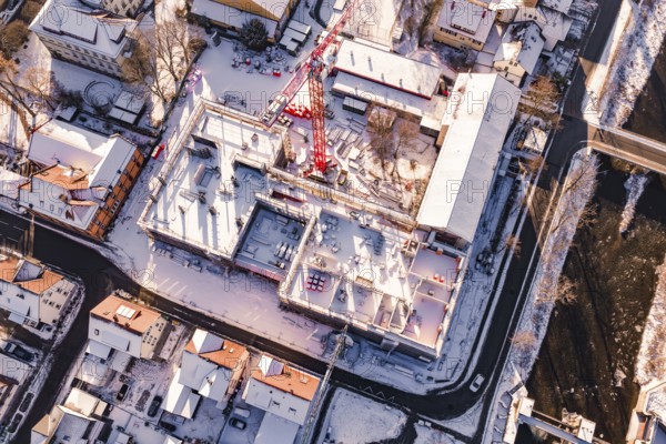 Bird's eye view of a snowy construction site between urban houses, Neubau Zellerschule, Nagold, Black Forest, Germany