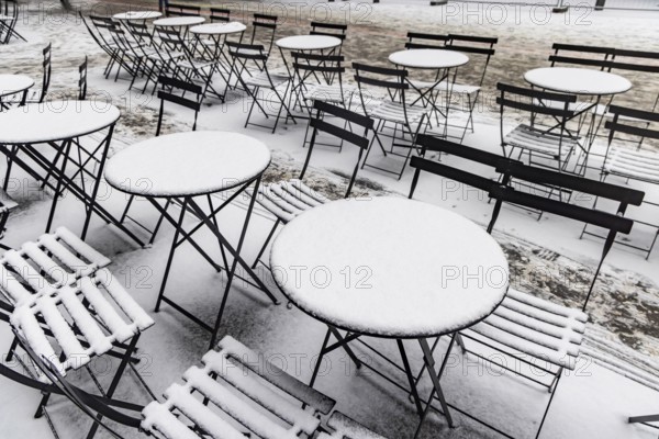 Winter in Stuttgart. Outdoor dining chairs and tables are covered with snow. Geometric structures. Stuttgart, Baden-Württemberg, Germany
