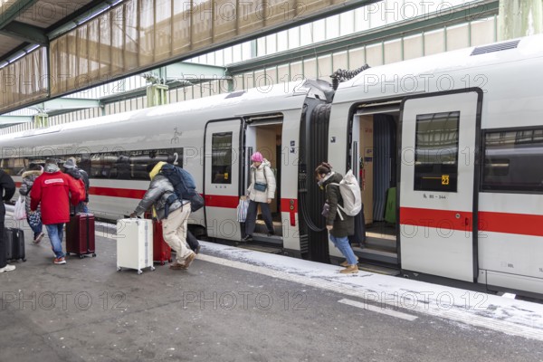 Winter in Stuttgart. There is also a closed layer of snow in the main train station. Travelers with suitcases disembarking from an ICE. Stuttgart, Baden-Württemberg, Germany