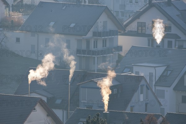 Sunrise over a village with smoking chimneys, calming morning atmosphere, symbolic image, fireplaces, gas heating, oil heating, fossil fuels, climate change, global warming, chimneys, Baden-Württemberg, Germany