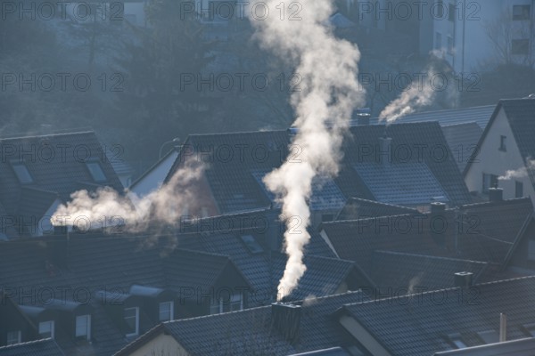 Snowy roofs and smoking chimneys under blue morning light in the city, symbolic image, fireplaces, gas heating, oil heating, fossil fuels, climate change, global warming, chimneys, Baden-Württemberg, Germany