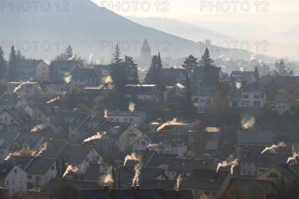 Extensive village panorama with smoking chimneys and hills in the morning haze, symbolic image, fireplaces, gas heating, oil heating, fossil fuels, climate change, global warming, chimneys, Baden-Württemberg, Germany