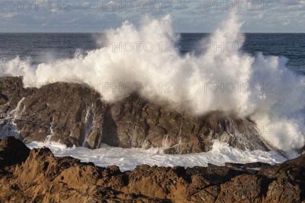 Powerful ocean swells hitting rocks at the mainland's eastern point. Crashing waves, Byron Bay, New South Wales, Australia