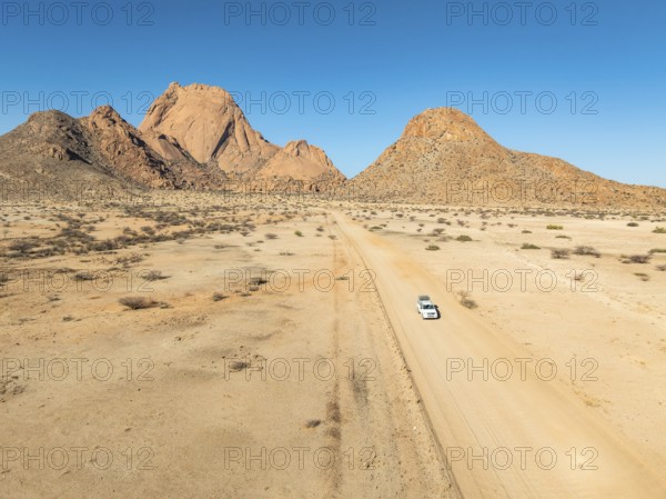 Aerial view, car on sandy road, mountains in the desert, Spitzkoppe summit, Namib desert, Namibia