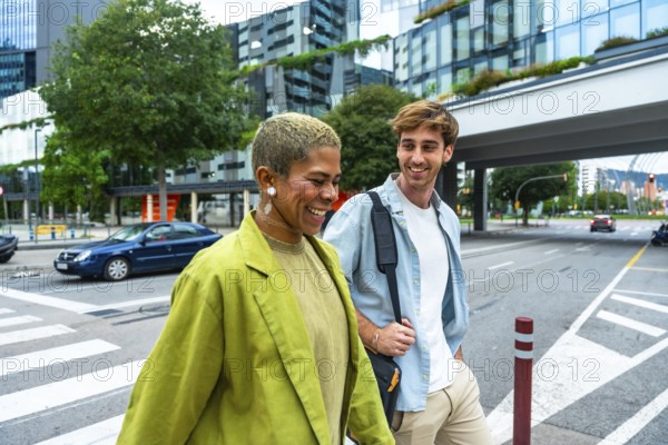 Two diverse colleagues smiling and walking together on a city street, representing collaboration, urban lifestyle, and a positive work relationship in a modern business environment