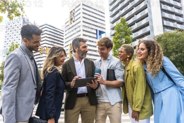 Diverse business professionals smiling and communicating, looking at a digital tablet together on a pedestrian crossing, representing teamwork, urban meeting, and modern collaboration in a city