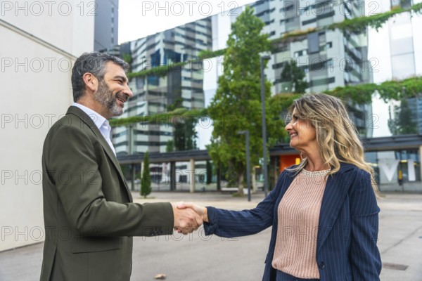 Two business colleagues exchanging a handshake in a modern city environment, symbolizing a successful partnership, agreement, deal, and professional collaboration outside the office