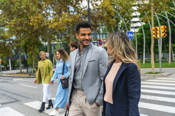 Group of executives and colleagues communicating while crossing a busy urban street, representing teamwork, diversity, and professional collaboration in a modern city environment