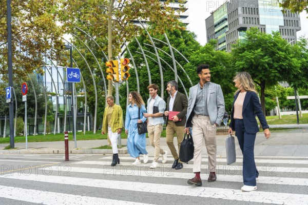 Diverse group of smiling business people walking across a street crosswalk in a modern city setting, collaborating as a team of professionals during urban commute