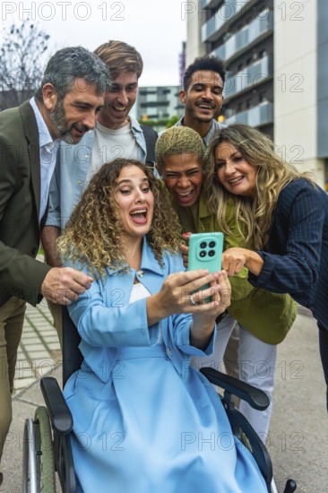 Diverse group of happy colleagues and friends, including a woman in a wheelchair, sharing a joyful moment and laughing while looking at a smartphone screen together in a modern city setting