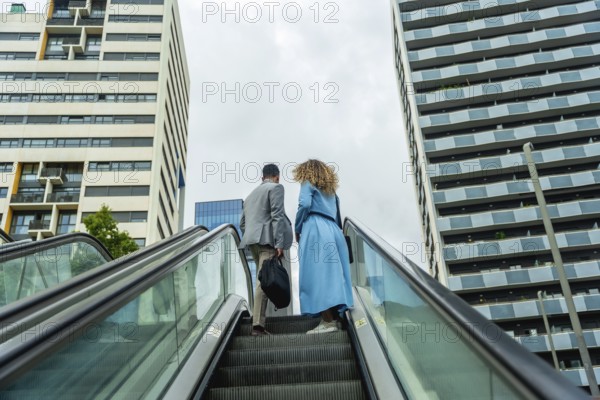 Business professionals ascending an outdoor escalator in a modern urban environment, symbolizing career progression, growth, and teamwork in a thriving city
